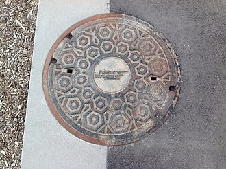 Manhole cover with the logo of PowerStream in Vaughan. PowerStreamManholeCoverVaughan2018.jpg