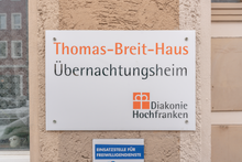 Das Foto zeigt das Schild, das darauf hinweist, dass hier das Übernachtungsheim (Thomas-Breit-Haus) ist