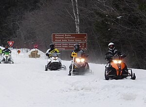 Photograph showing snowmobiles using a snow-covered H-58