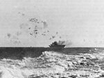 L'USS Enterprise en feu le 24 août 1942. Les explosions des obus antiaériens sont clairement visibles au dessus du navire.