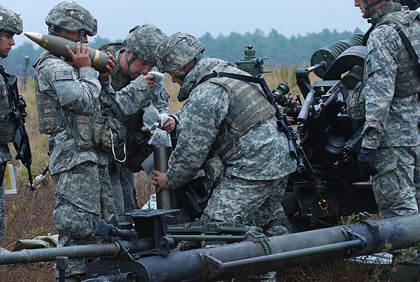 Preparing 105 mm M119 howitzer ammunition: powder propellant, cartridge, and shell with fuze