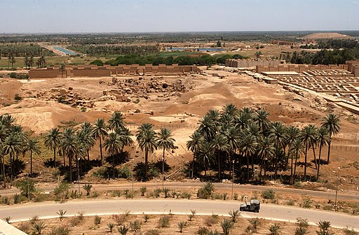 US Navy 030529-N-5362A-001 A U.S. Marine Corps Humvee vehicle drives down a road at the foot of Saddam Hussein's former Summer palace with ruins of ancient Babylon in the background