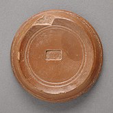 Inscripción en caracteres griegos en el envés de una pieza de terracota hallada en Egipto y datada en hacia 332 a. C. - 337 d. C.