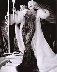 Mae West wearing the black lace dress in Go West, Young Man (1936). The design inspired the bottle of the line's debut fragrance. West, Mae (Go West Young Man).jpg