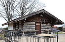 Historic log cabin structure built atop a historic hand-dug wine cellar with a concrete patio now serving as the winery's restaurant