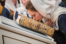 Noia besant l'evangeli de l'altar a Sant Petersburg (Rússia).