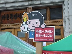 A close up picture of Candle-light girl, an iconic character created by protest organizers. The slogan reads, "All candles together, till our goals are achieved". Photo taken in front of Seoul City Hall on 6 June 2008. 080606 ROK Protest Against US Beef Agreement 03.jpg