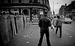 A Metropolitan Police Inspector (centre) during the 1981 Brixton Riots wearing a custodian helmet with two silver bands to denote his rank