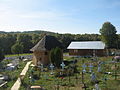 Biserica de lemn, praznicarul şi cimitirul văzute din clopotniţă