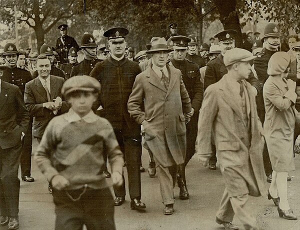 Jack MacDonald is escorted away by police after a failed attempt to hold a free speech rally in Queen's Park, Toronto, 1929.