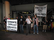 At a demonstration at BMVIT, banners read, "Democracy needs anonymity - stop data retention" (left) and "Liberty dies with security" (right). Demonstration data retention at BMVIT Florian Hufsky Rickard Falkvinge 2007-06-07.jpg