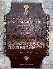 A bronze plaque with an image of the Medal of Honor, inscribed with MacArthur's Medal of Honor citation. It reads: "For conspicuous leadership in preparing the Philippine Islands to resist conquest, for gallantry and intrepidity above and beyond the call of duty in action against invading Japanese forces, and for the heroic conduct of defensive and offensive operations on the Bataan Peninsula. He mobilized, trained, and led an army which has received world acclaim for its gallant defense against a tremendous superiority of enemy forces in men and arms. His utter disregard of personal danger under heavy fire and aerial bombardment, his calm judgment in each crisis, inspired his troops, galvanized the spirit of resistance of the Filipino people, and confirmed the faith of the American people in their Armed Forces."