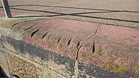 Marks on promenade stonework cut by cables as boats were hauled ashore.