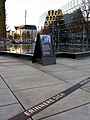 Gedenkbrunnen auf dem Platz der Alten Synagoge in Freiburg mit neu angebrachtem Bronzeband, das zum Erinnern an die zerstörte Synagoge an diesem Platz anhalten soll, im Hintergrund die Universitätsbibliothek