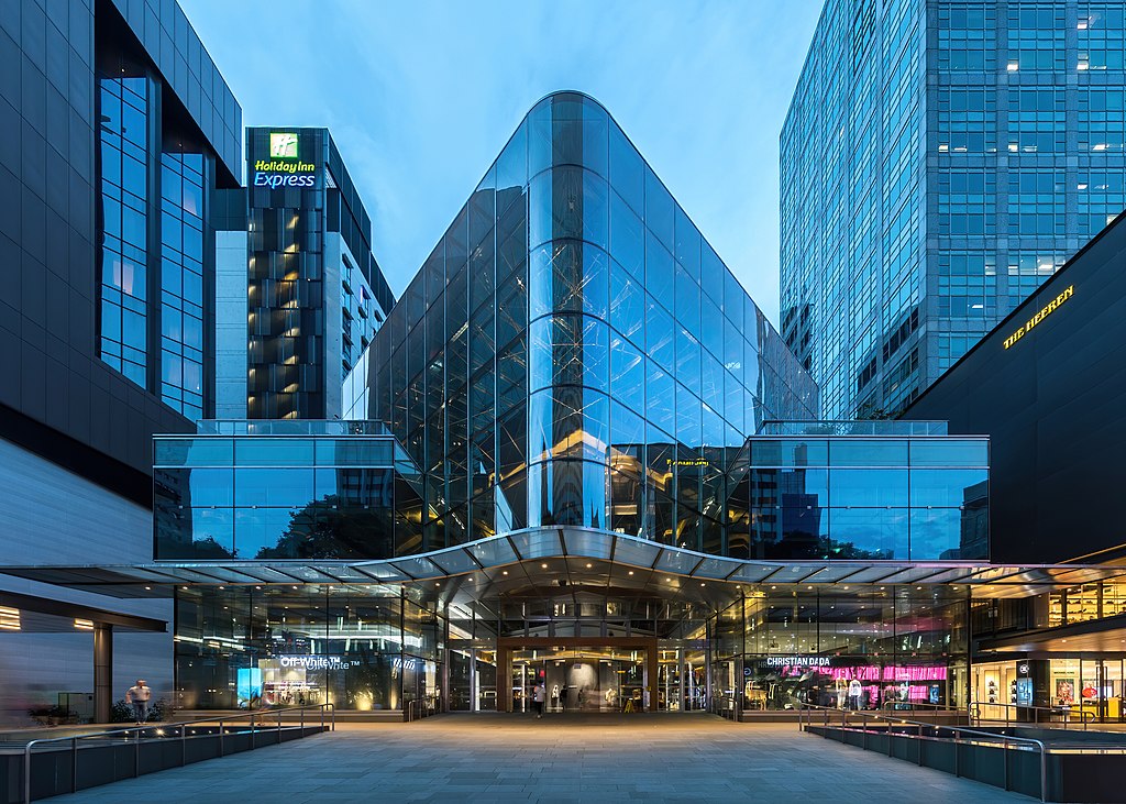 Glass facade of an illuminated shopping mall at blue hour with vertical symmetry impression, Orchard Road, Singapore