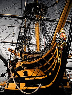 La proue du trois-mâts HMS Victory, navire musée amarré à Portsmouth. Il fut le navire amiral d'Horatio Nelson durant la bataille de Trafalgar (1805). À son plus haut mât fut hissé, en prélude à la bataille, le célèbre signal par pavillons « England expects that every man will do his duty ». (définition réelle 2 250 × 2 952)