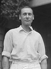 A man standing wearing cricket whites