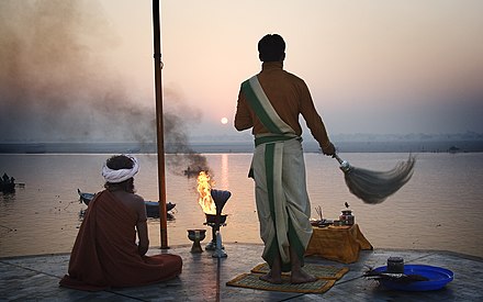 Hindu priest saluting the sun in the Ganges