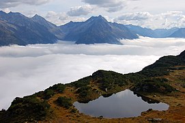 Гірське озерце і туман в долині поблизу вершини Саннінг-Грат в Альпах, Урі, Швейцарія