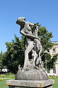 Une statue de femme nue avec une biche, dans un jardin public.