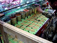 Shopkeeper making paan in an Indian store.