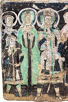 Tocharian royal family of the Kingdom of Kucha (king, wearing a close-fitting, belted caftan with chequered lozenge pattern, queen in a green robe, and fair-haired young princes), Kizil Cave 17. Circa 500
.mw-parser-output span.smallcaps{font-variant:small-caps}.mw-parser-output span.smallcaps-smaller{font-size:85%}
AD. Royal family, Cave 17, Kizil (family detail, retouched).jpg