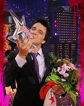 Nader Guirat winner of Star Academy 5 carrying the Tunisian flag and the trophy on stage at the show's finale