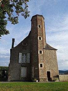 Kleurenfoto van een oude toren, opgebouwd uit kiezelstenen.