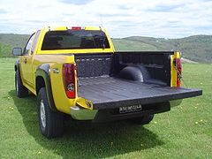 Flat sided pickup truck showing wheel well intrusion into bed.