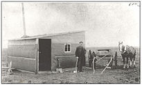 The first house in Regina (1882) Unidentified man with horse and cart beside the first house built in Regina..jpg