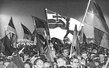 Homemade Reichskriegsflagge at a German reunification in Berlin celebration in 1990 Bundesarchiv Bild 183-1990-1003-004, Berlin, Vereinigungsfeier, Fahnen.jpg