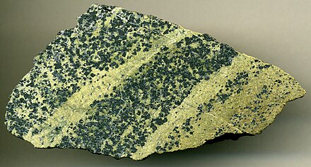 Chromitic serpentinite (7.9 cm (3.1 in) across), Styria Province, Austria. Protolith was a Proterozoic-Early Paleozoic upper mantle dunite peridotite that has been multiply metamorphosed during the Devonian, Permian, and Mesozoic.
