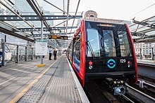 An automated Docklands Light Railway train at Heron Quays, in the Canary Wharf financial district Docklands Light Railway 129 (6851775078).jpg