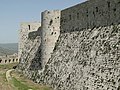 Pravokoten in krožen stolp štrlita iz obzidja v Krak des Chevaliers.
