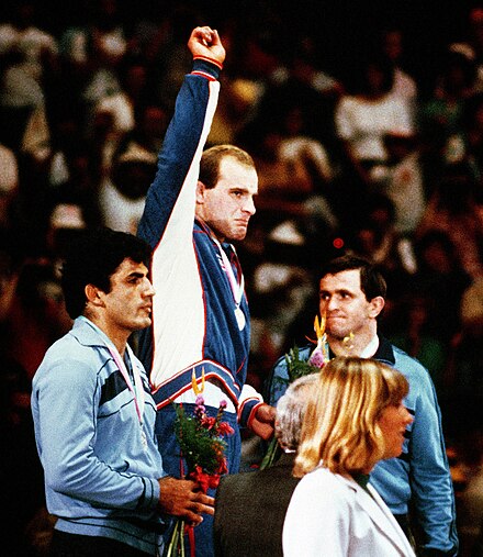 Wrestlers greet the crowd at a medal ceremony.