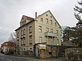 Posthalterei und Ausspanne (Nr. 49) mit einem Bau an der Straße sowie Wohnhaus (Nr. 51) in offener Bebauung, Einfahrt mit verschiedenen Torsäulen zur Dresdner Straße und nach hinten, Stützmauern, Einfriedung, gestalteter Garten unter anderem mit Steinvase und hölzerner Gartenlaube