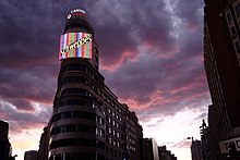 The neon Schweppes sign where José María hangs from is on the Edificio Carrión.[4]