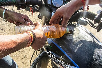 Refuelling a motorbike from petrol sold in a water bottle