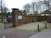 De uit 1931 daterende muur rond de begraafplaats