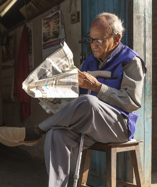 File:Old man reading newspaper early in the morning at Basantapur-IMG 6800 (cropped).png