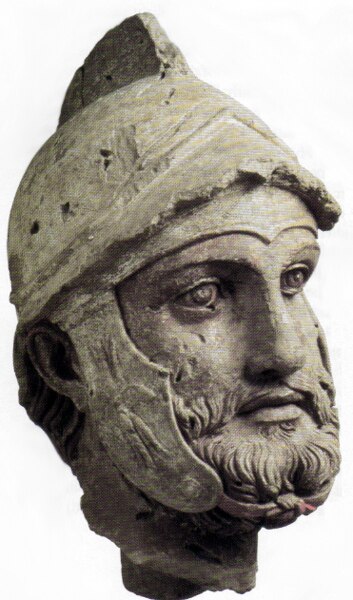 A sculpted head (broken off from a larger statue) of a Parthian warrior wearing a Hellenistic-style helmet, from the Parthian royal residence and necr