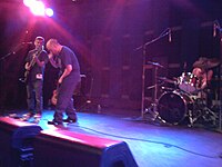 After two performances in 2004, Genaro (left) reformed the Dead Milkmen in 2008 with original members Rodney Linderman and Dean Sabatino. The Dead Milkmen in performance, 2010.jpg