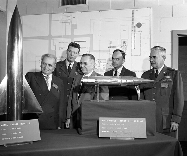 Theodore von Kármán, left, is joined by Air Force and NASA officials while inspecting two of the models used in the high velocity, high altitude wind 