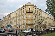 Photograph of the corner facing of a four-story building made of yellow block