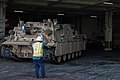 A Stevedore with the Port of Savannah ground-guides a Soldier assigned to 2nd Brigade Combat Team driving an M88A2 (Hercules) aboard a military transport vessel in support of DEFENDER-Europe 20 at the Port of Savannah, Ga. February 12, 2020.