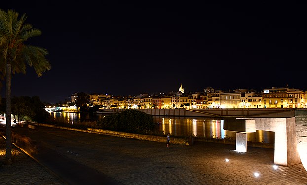 The Canal de Alfonso XIII and the Calle Betis, in Seville (Spain), at night.