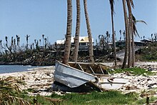 A picture showing damage to a beach and a boat caused by Tropical Cyclone Val