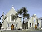 The church is linked by flat-roofed section to the church hall, which has a Neo-Classical gable facade with a lower pitch. The saddle roof is covered with slate and has a lower pitch than the church. It is richly decorated. The walls are rusticated with Architectural style: Neo-Classical. Current use: Church Hall. Dudley Hall Graaff Reinet-001.jpg