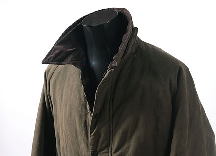 A men's green waxed jacket with brown corduroy collar.