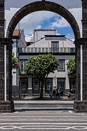 Locals seen through one of the arches of Portas da Cidade, Ponta Delgada, São Miguel Island, Azores, Portugal